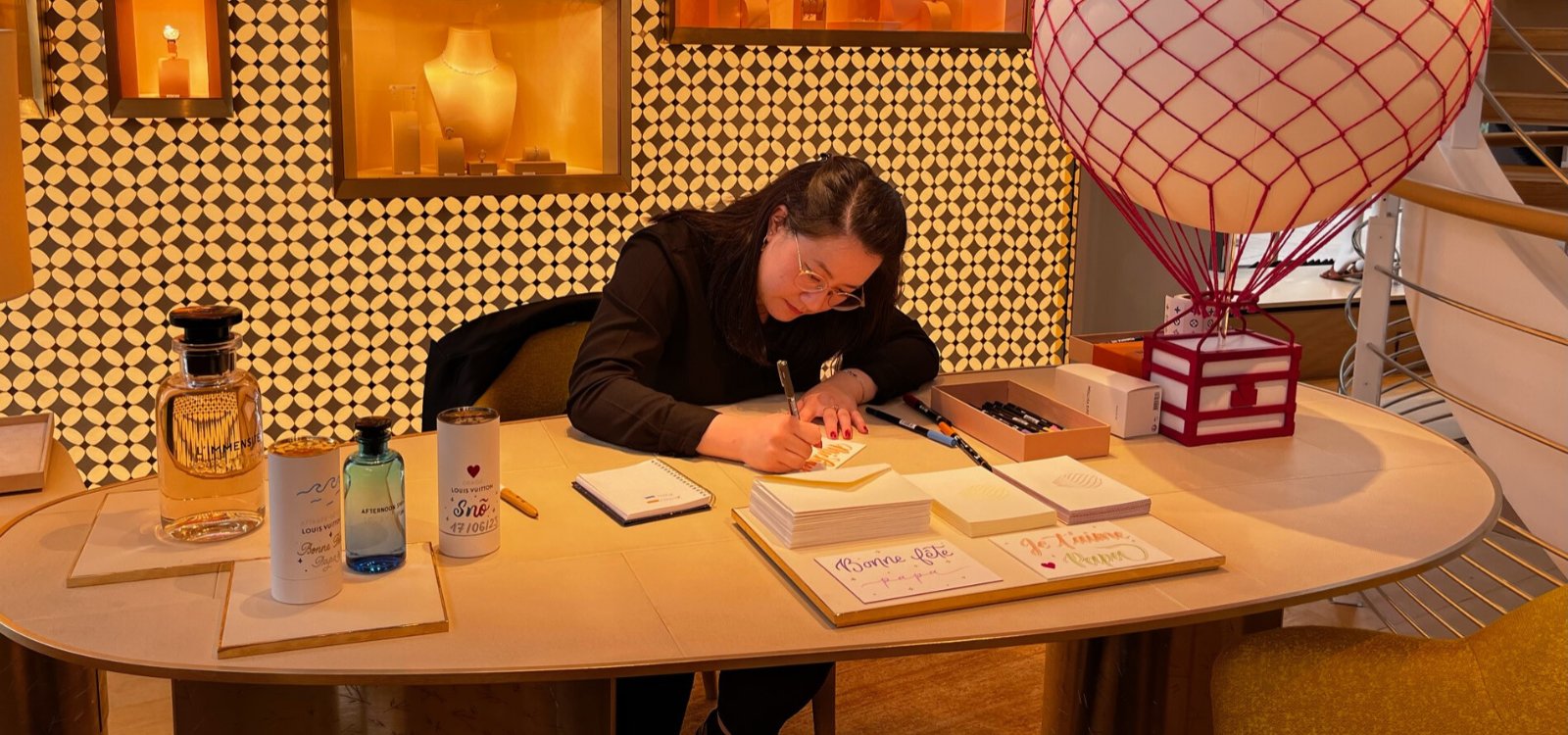 Cathy entrain de rédiger des cartes de voeux pour les clients de Louis Vuitton