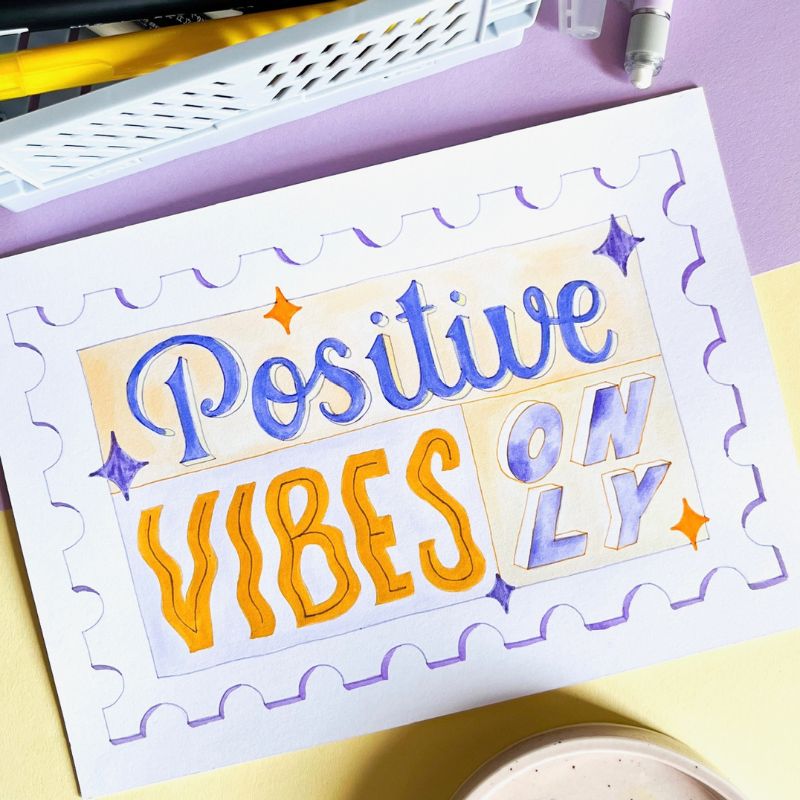 Lettering : "Positive Vibes Only" à l'aquarelle de couleurs violets et jaunes.