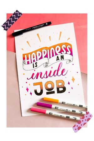 Brushlettering sur papier bristol A4. Il est écrit "Happiness is an inside Job".